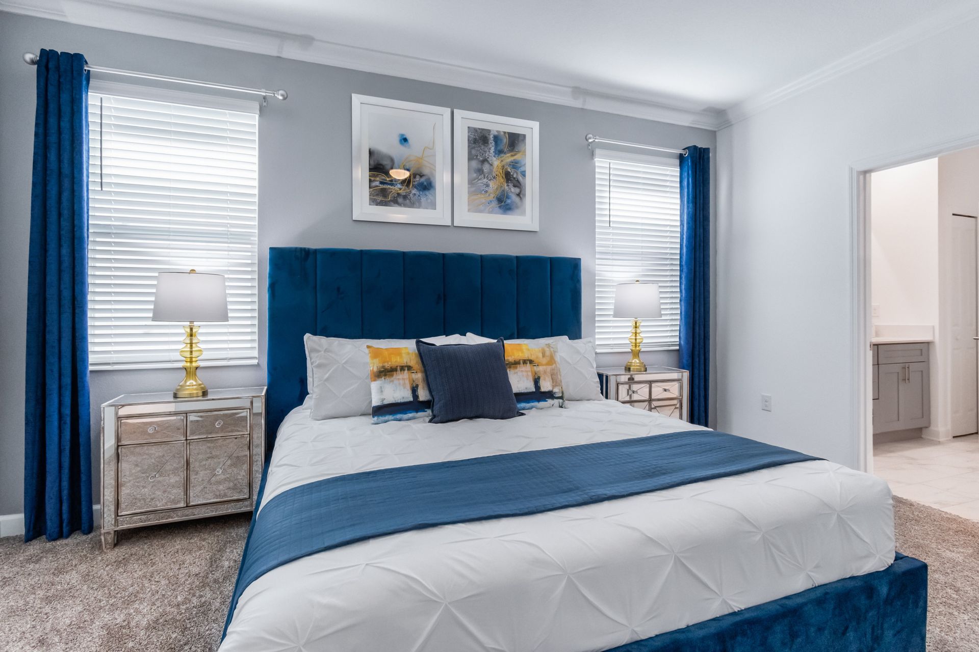 Chic bedroom retreat with plush king bed, bold blue headboard, and stylish decor
