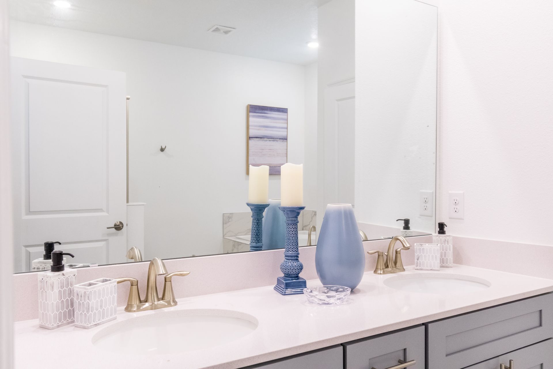 Serene bathroom with double vanity, soft blue decor, candles, and elegant details
