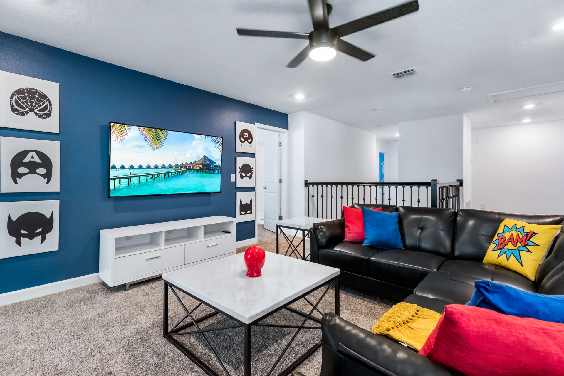 Superhero-themed loft with comfy leather sofa, big TV, colorful pillows, and decor
