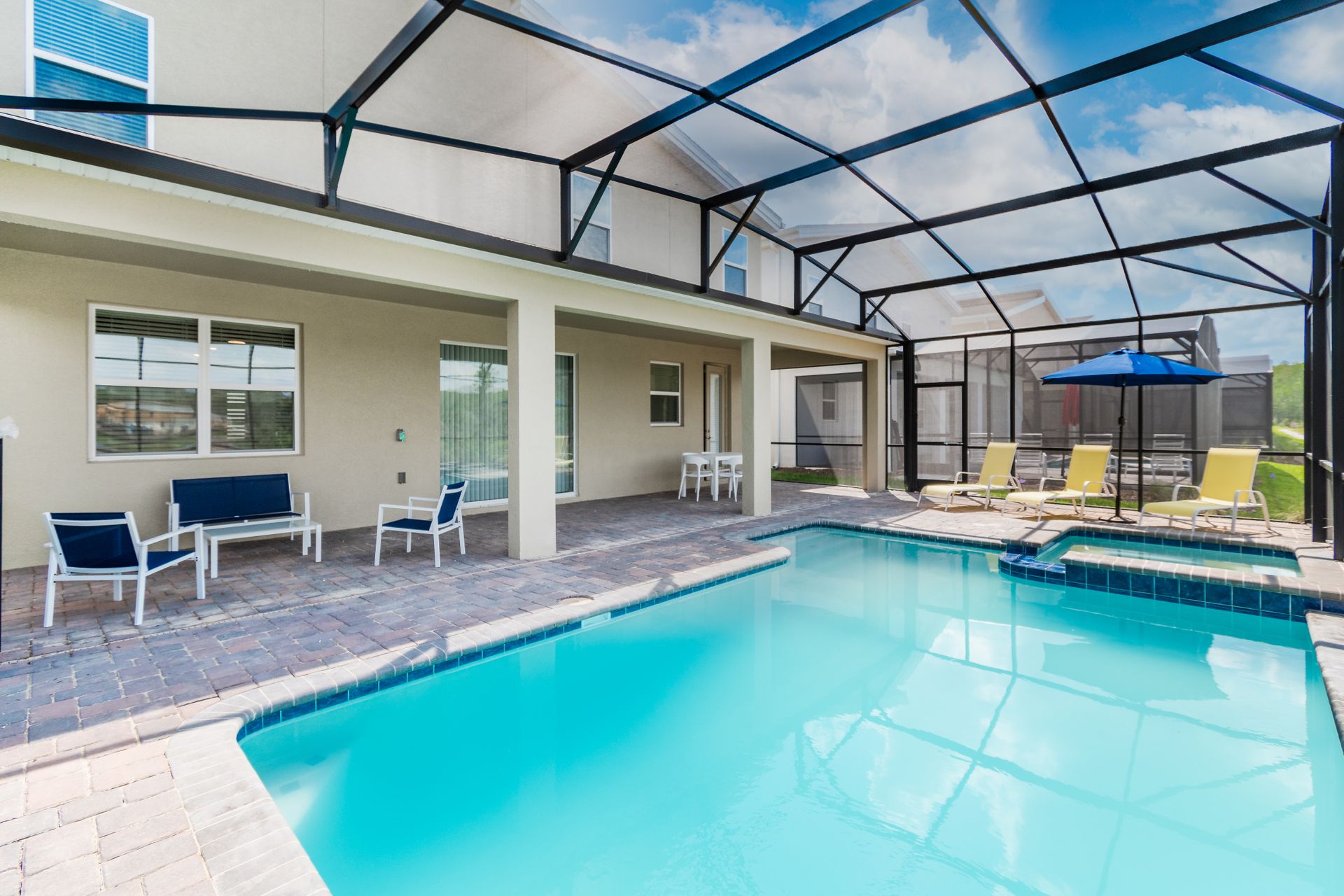 Relaxing screened pool and spa with sunny loungers, covered patio, and seating area
