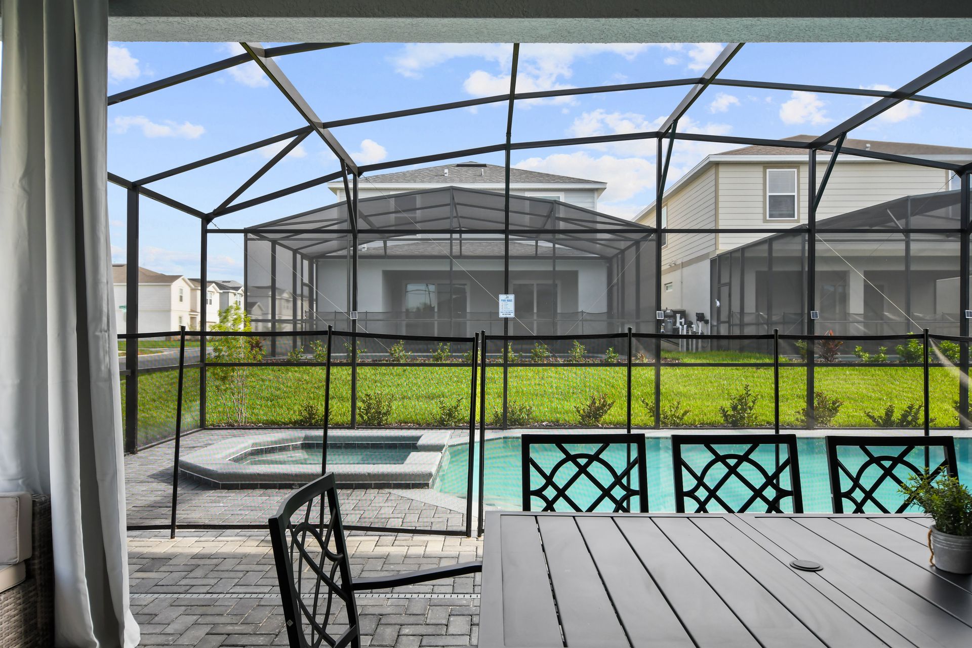 Relax in the screened-in pool and hot tub with outdoor dining space.