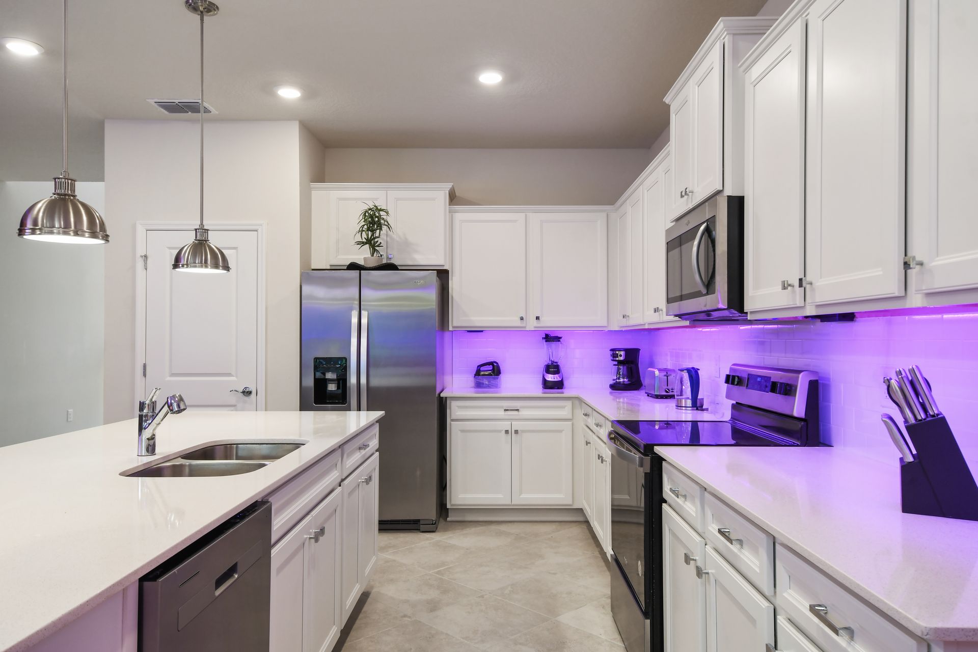 Bright, modern kitchen with stainless steel appliances, island, and LED accents.