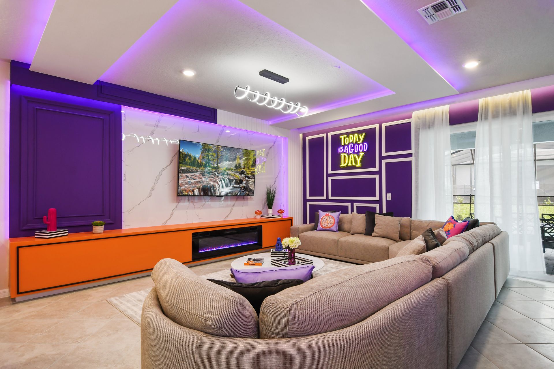Modern living area with vibrant neon decor, plush sectional, and sleek design.