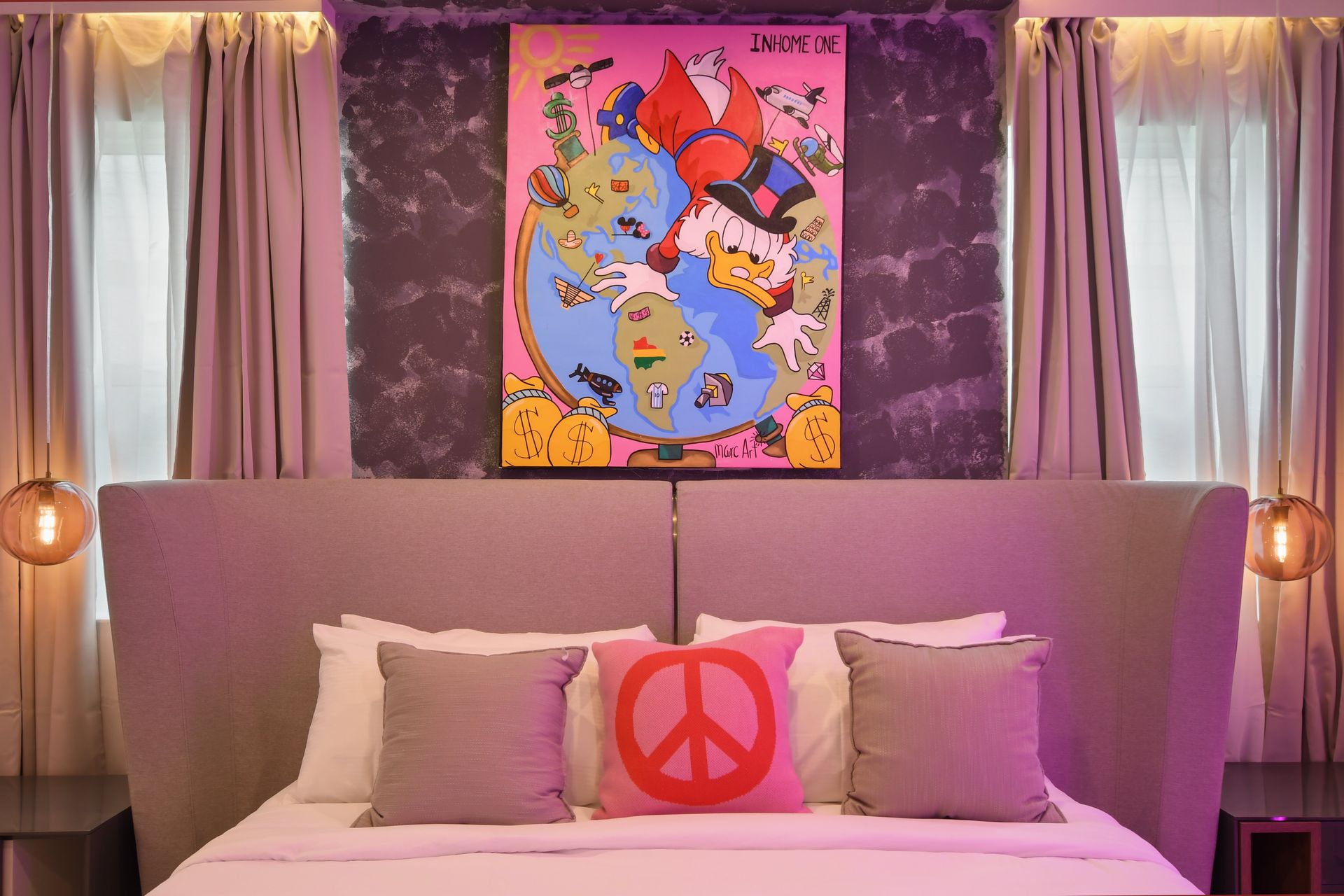 Cozy bedroom with unique wall art, soft lighting, and a peace-themed pillow.