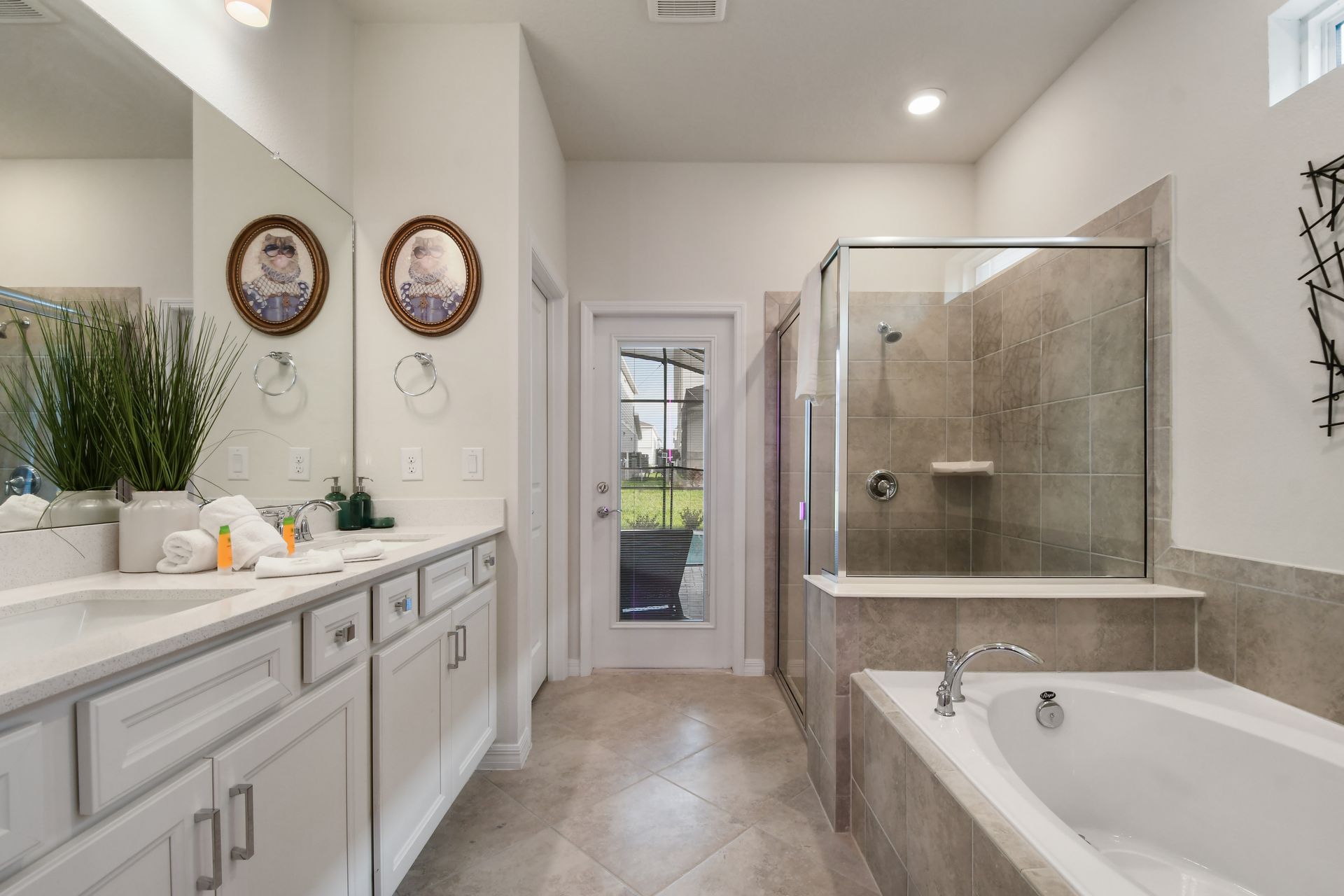 Luxurious bathroom with dual sinks, glass shower, and inviting bathtub.