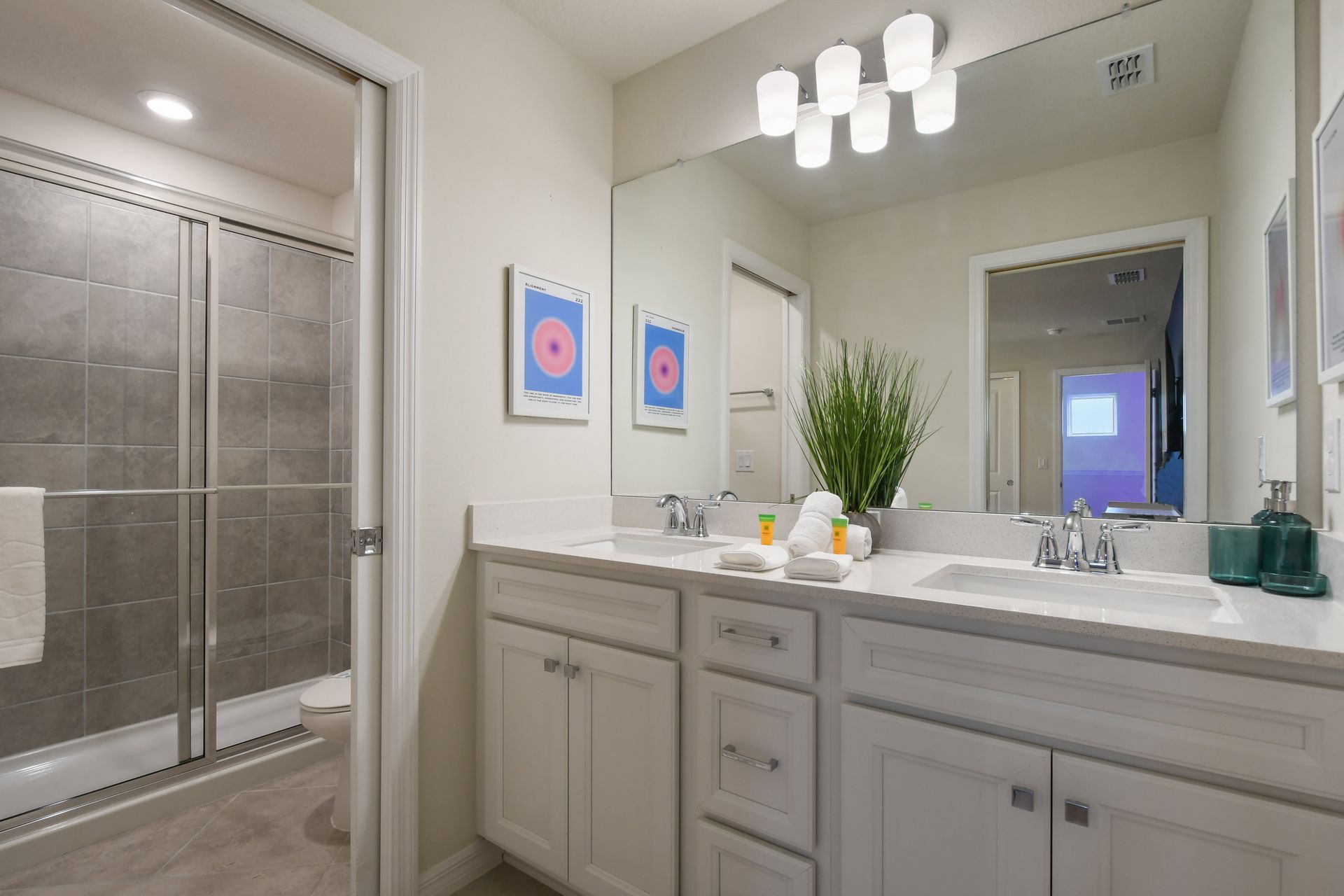 Bright, modern bathroom with a spacious shower and dual sinks.