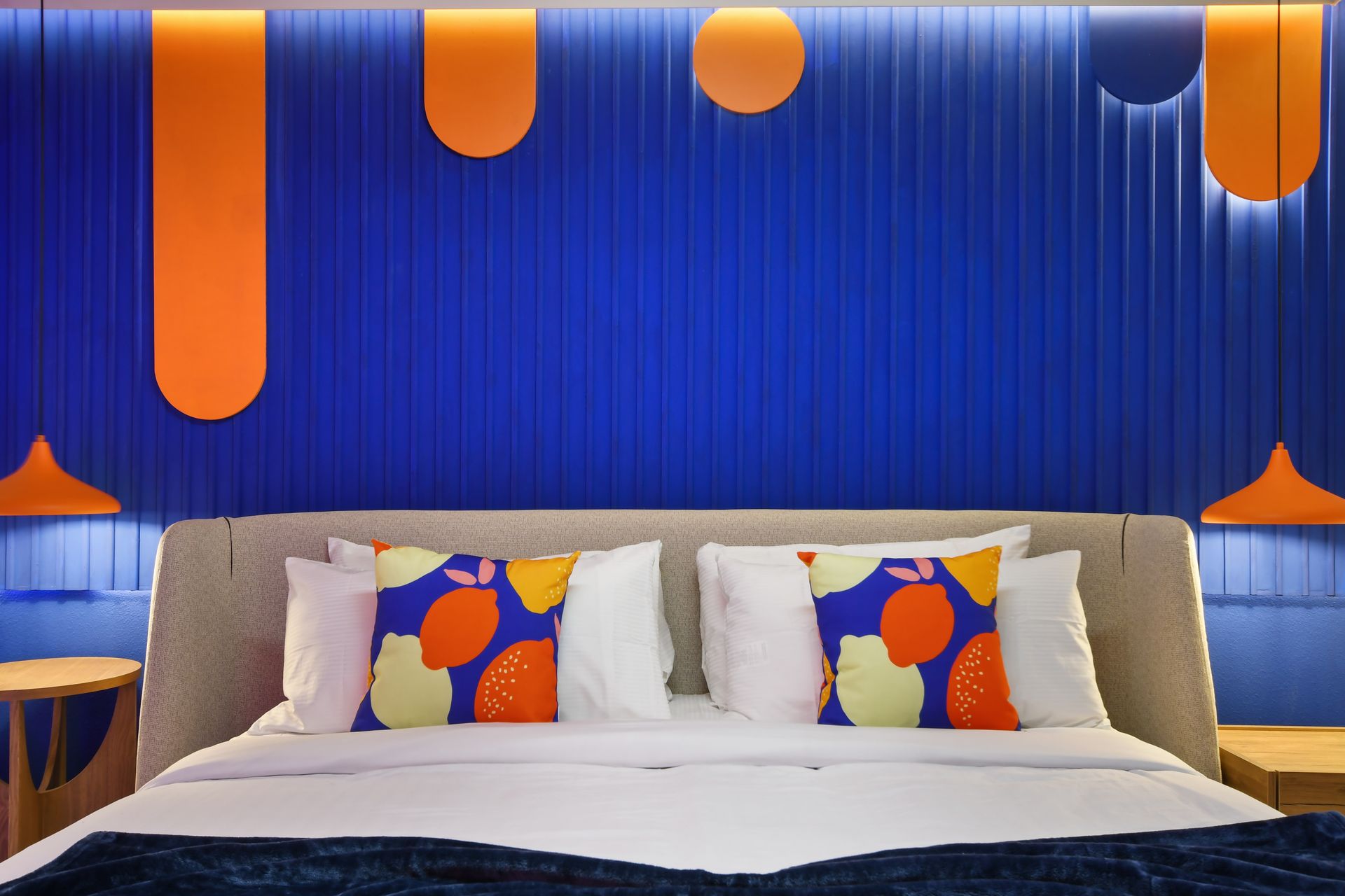 Vibrant blue and orange bedroom with bold patterns and modern accents.