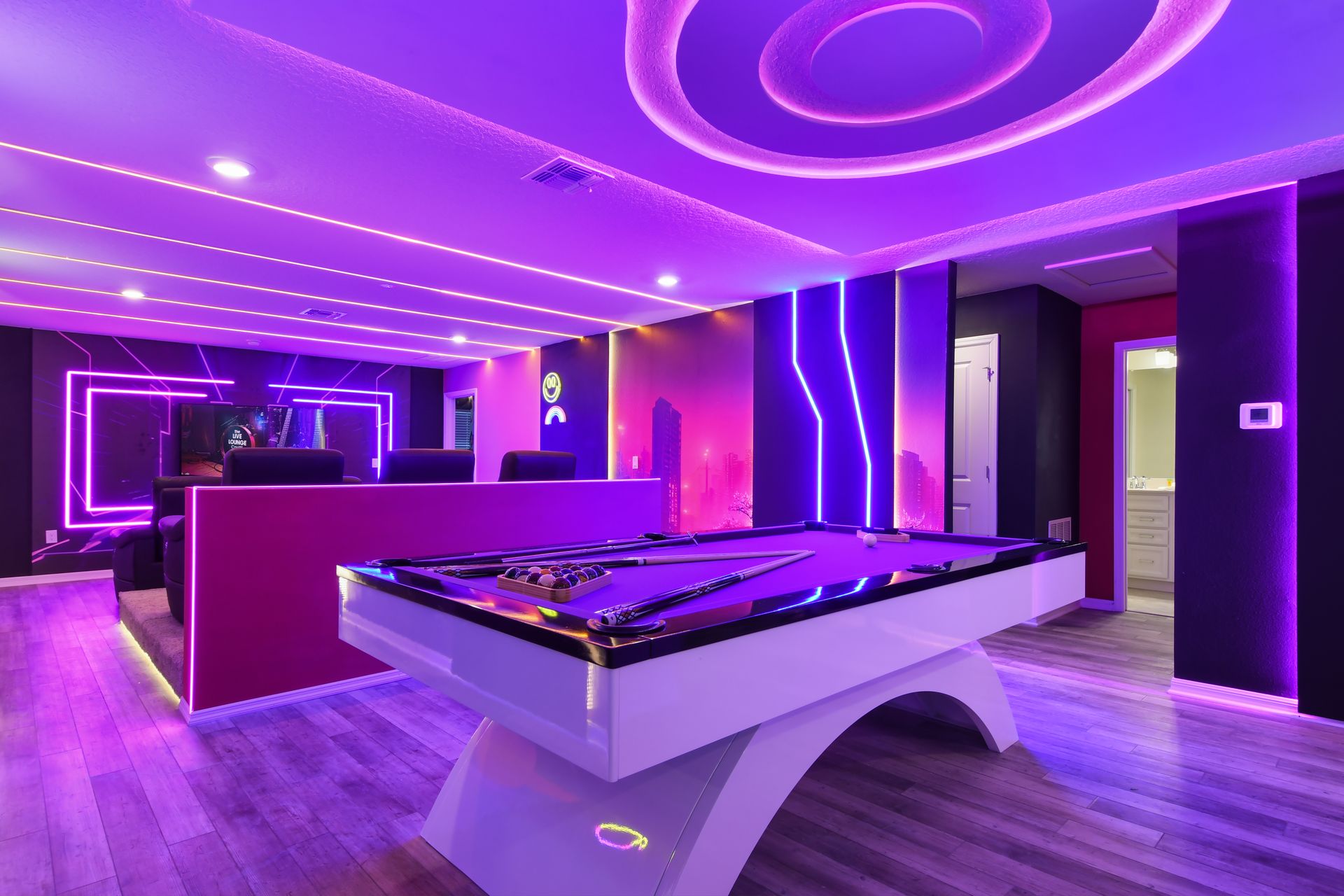 Vibrant game room with neon lights, pool table, and futuristic ambiance.