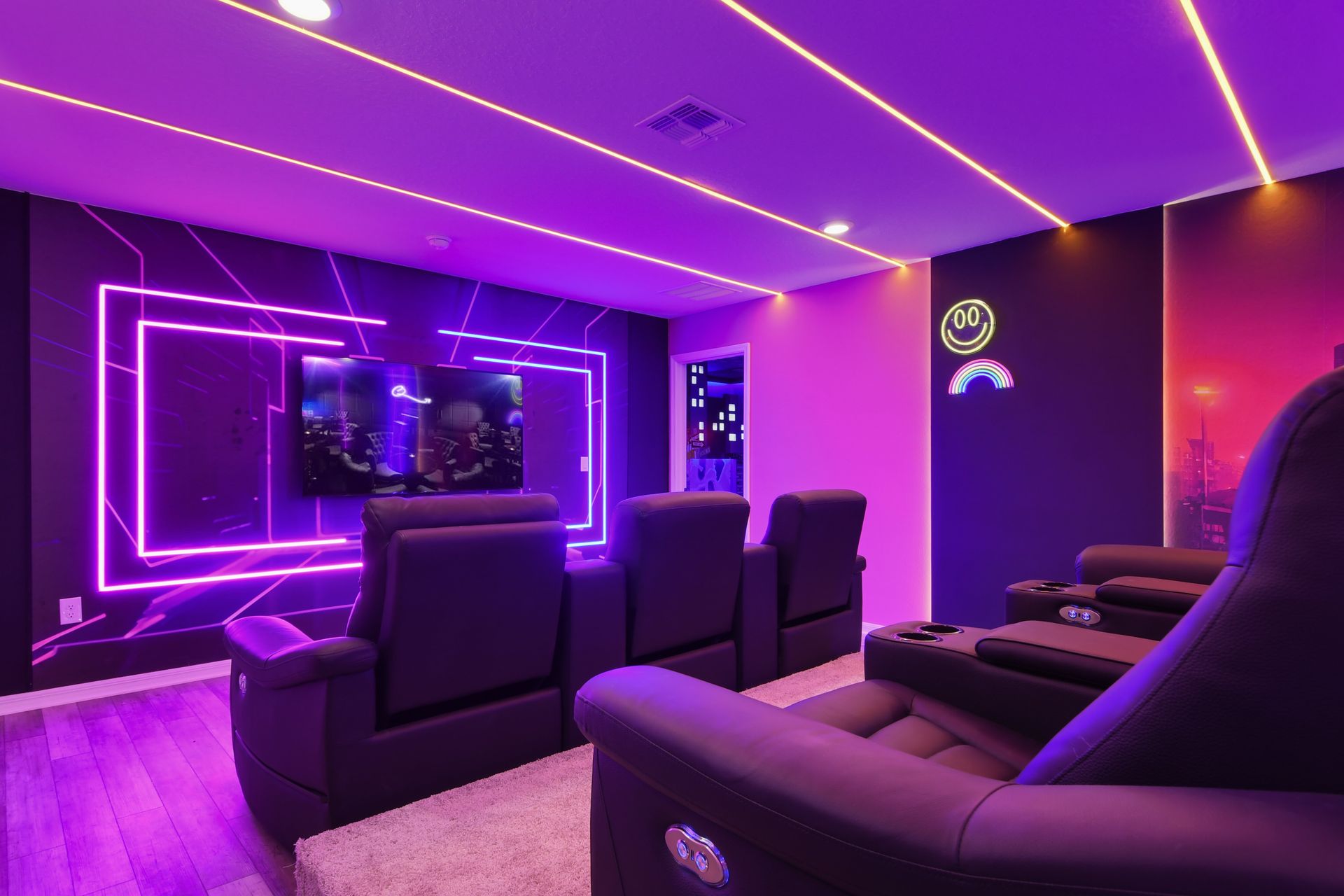 Neon-lit home theater with cozy recliners for an immersive movie experience.