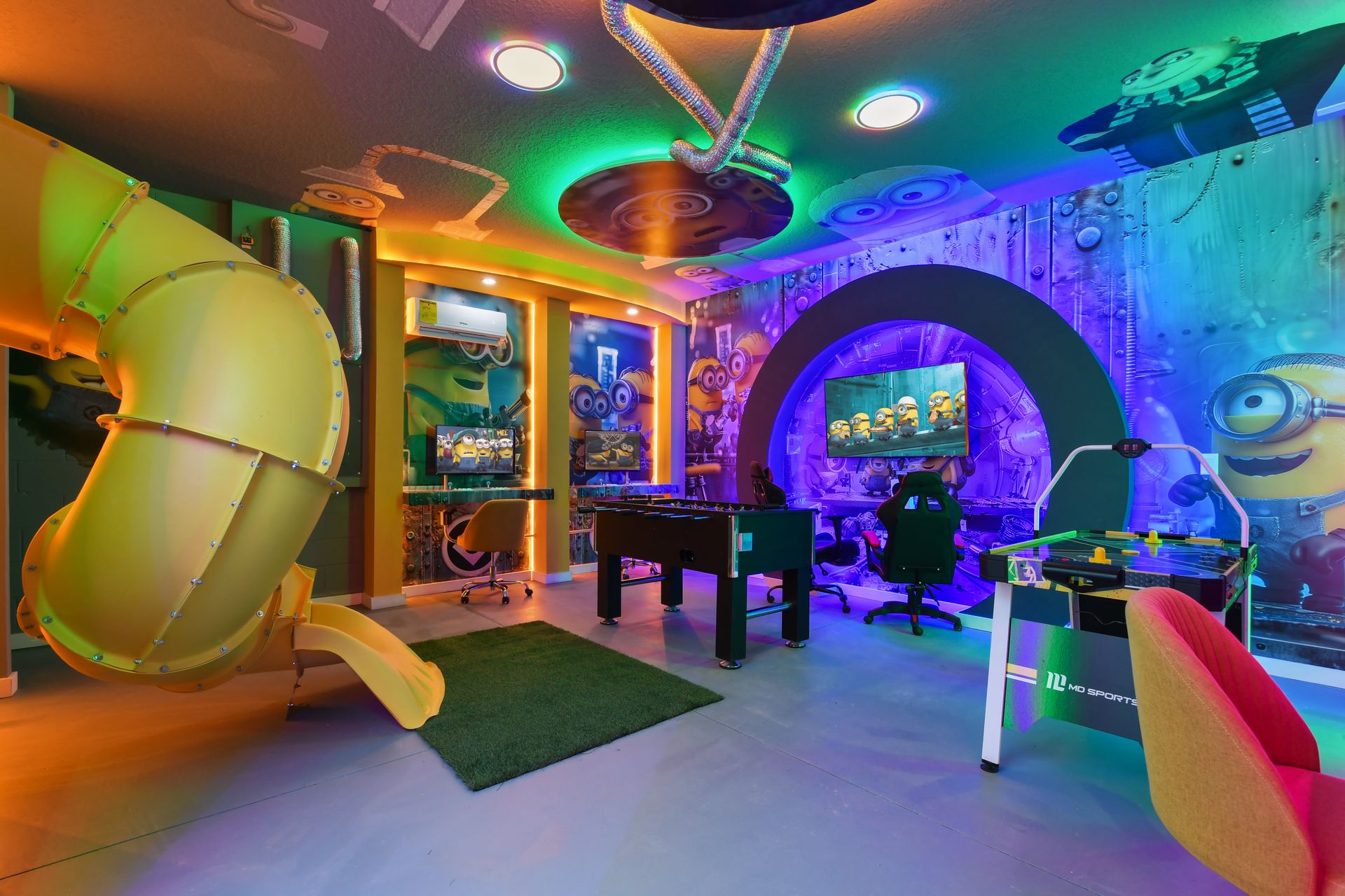 Minion-themed game room with slide, arcade games, and vibrant neon lighting.
