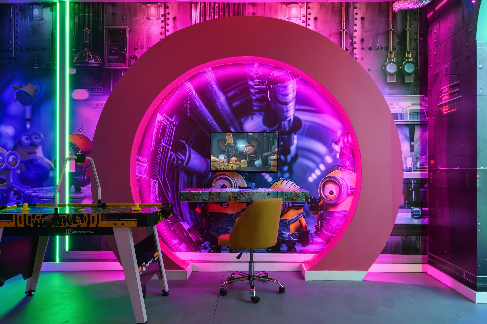 Minion-themed game room with vibrant lighting, air hockey, and gaming station.