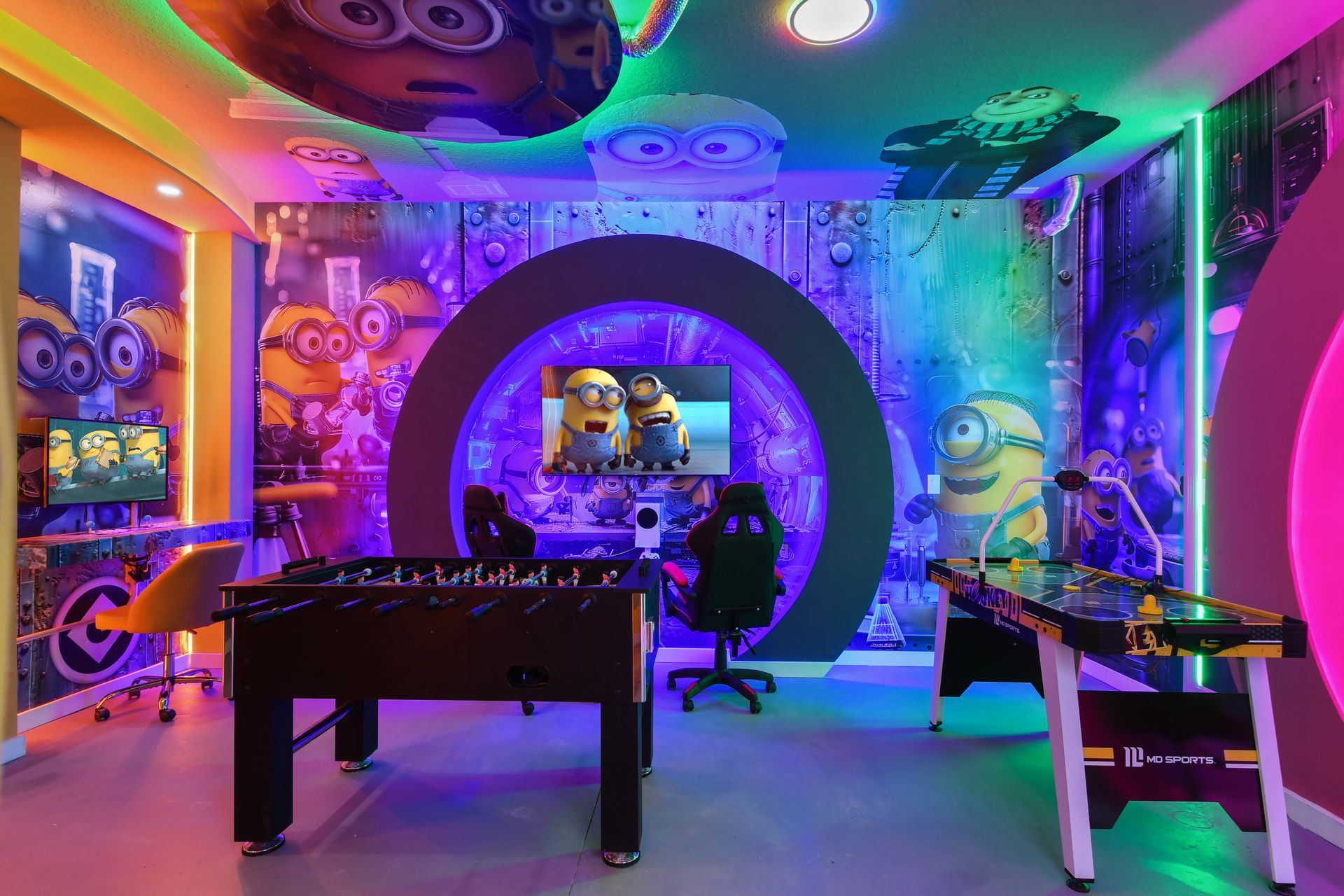 Minion-themed game room with foosball, air hockey, gaming stations, and neon lights.