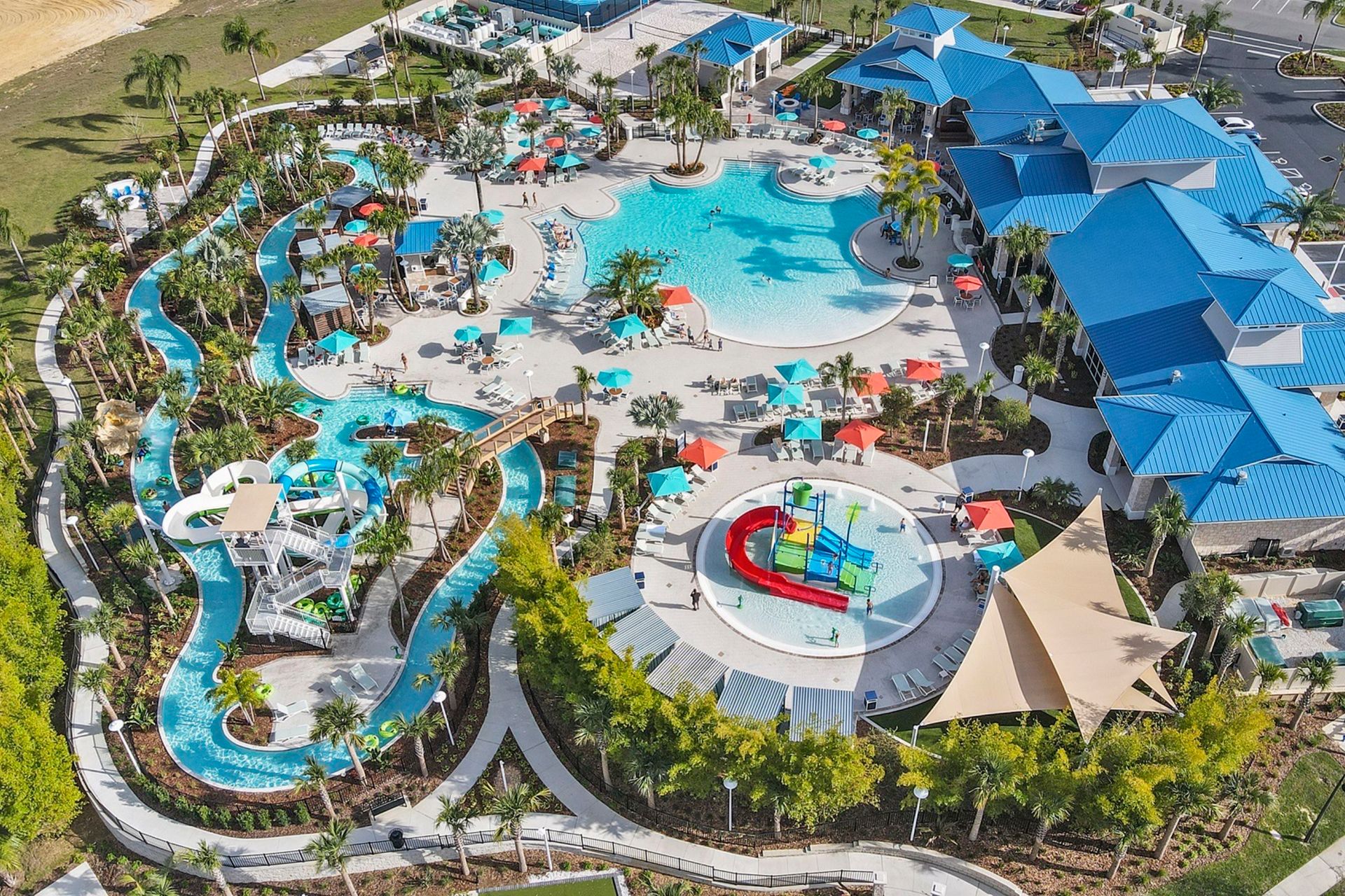 Aerial view of an expansive resort waterpark with lazy river, slides, splash pad, and family pools.