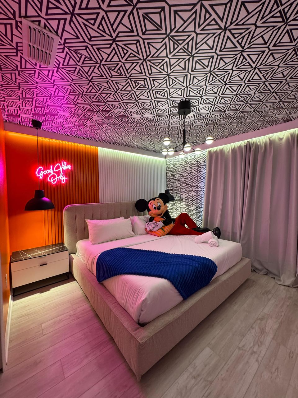 Trendy bedroom with bold patterns, neon lights & cozy vibes!