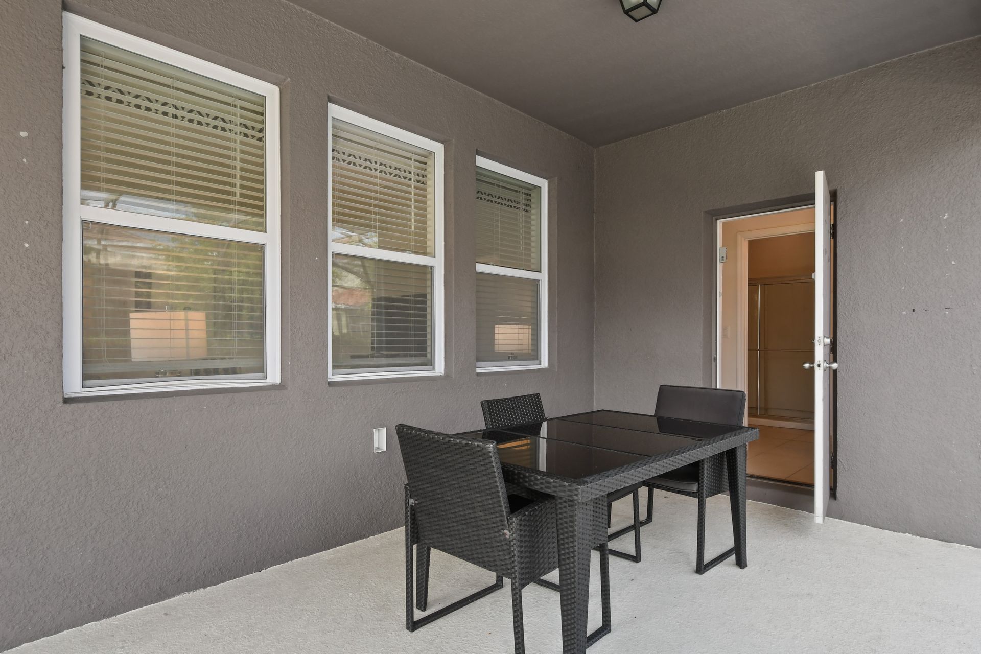 Cozy covered patio with seating for four, perfect for outdoor dining or games.