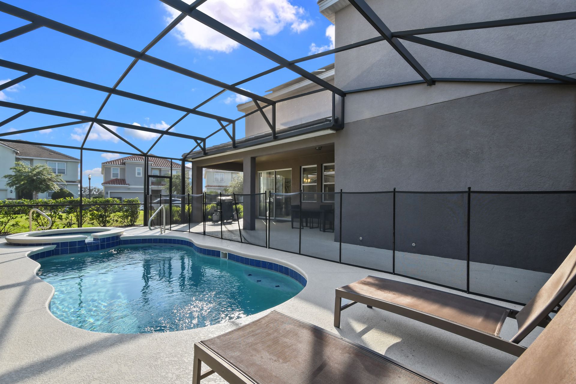Private screened pool with spa, sun loungers, and serene outdoor vibes.