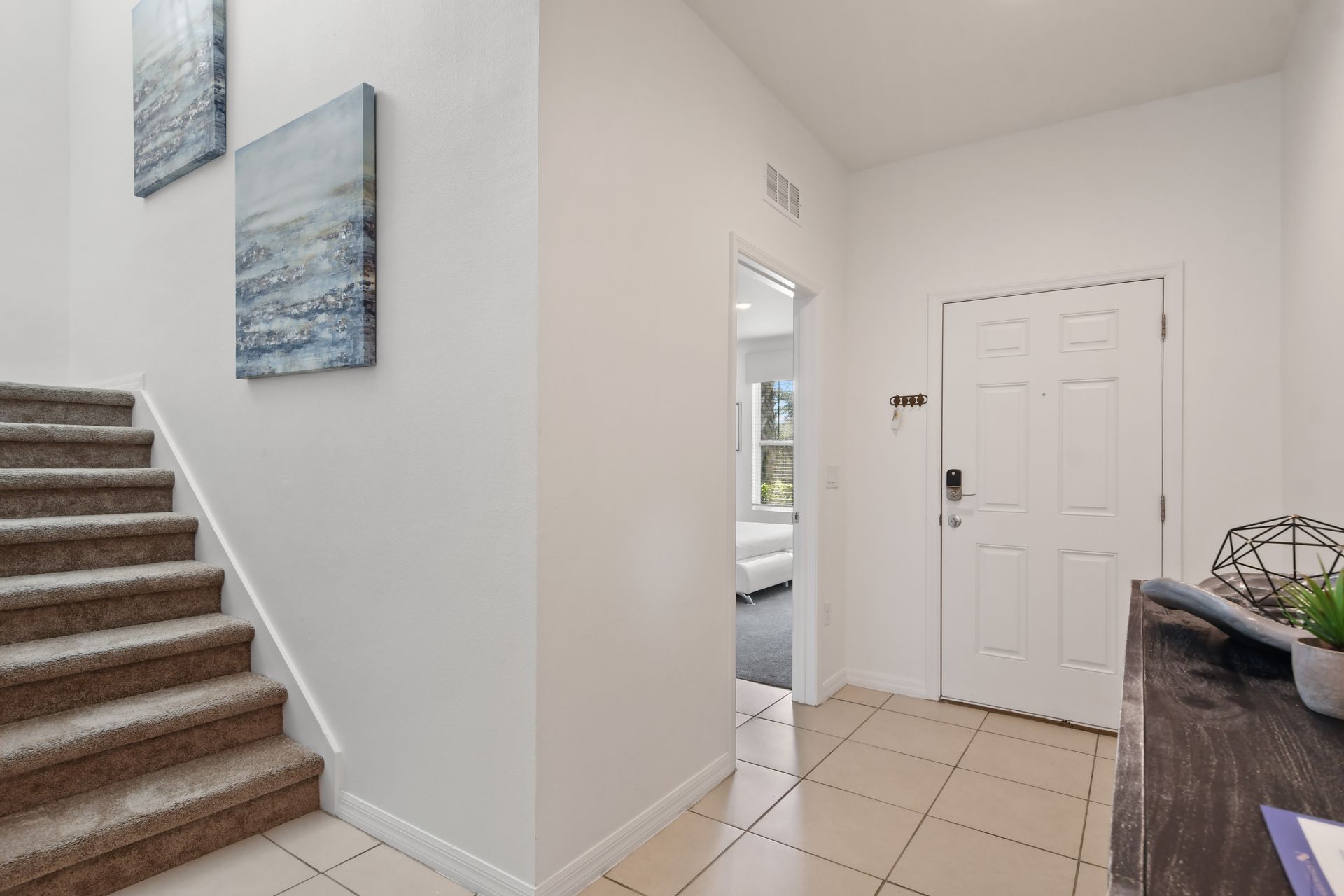 Bright and modern entryway with direct access to bedroom and upstairs area.