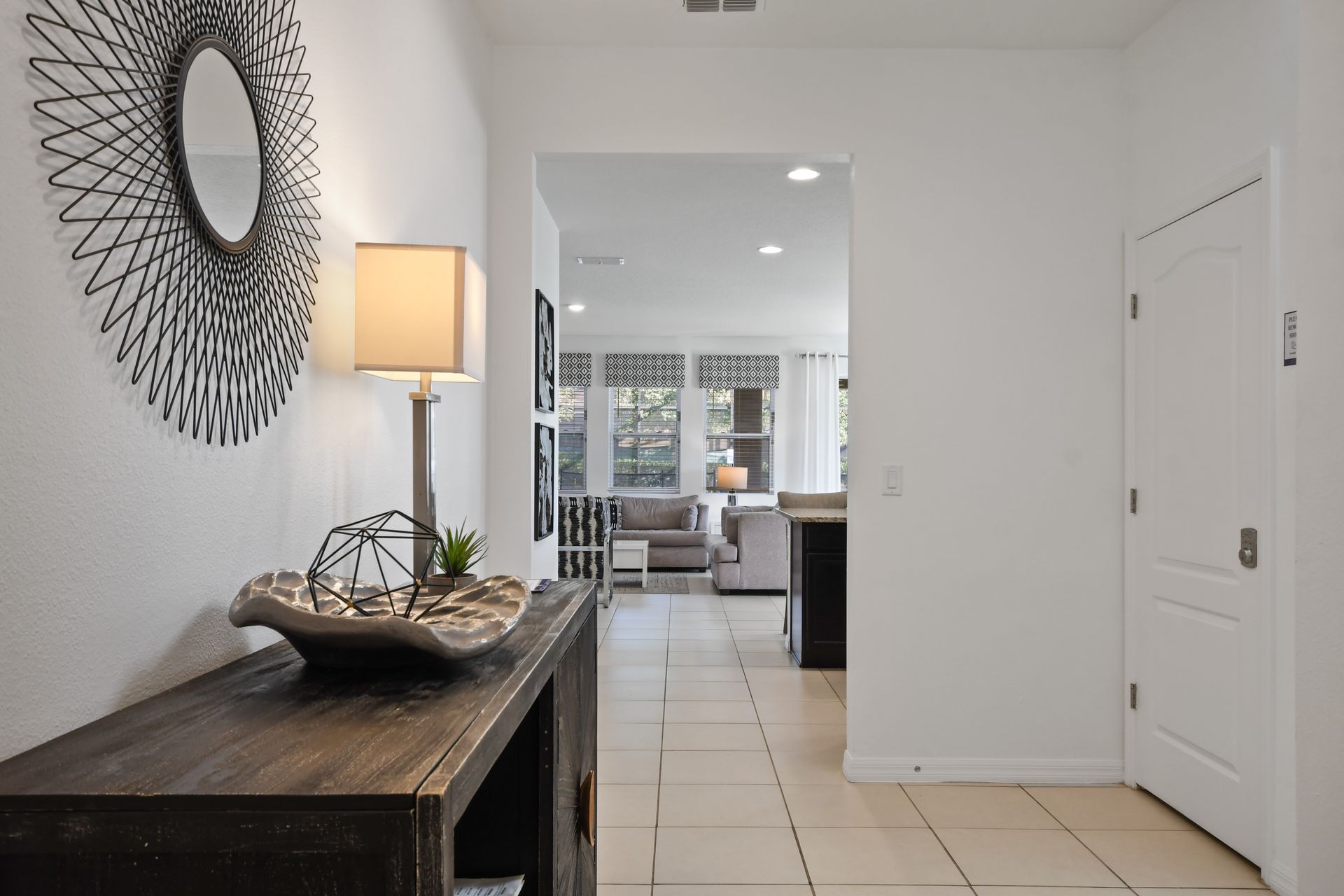 Stylish hallway leads to an open living space with cozy seating and natural light.