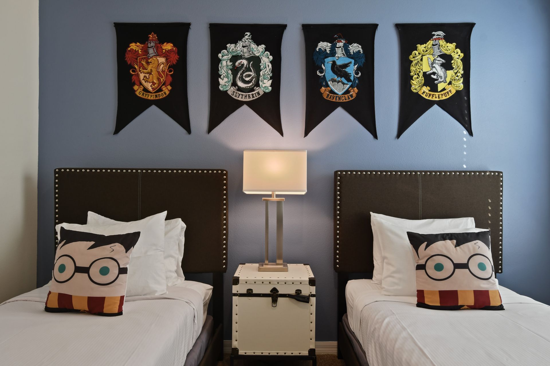 Charming twin bedroom with a magical wizarding theme and cozy character pillows.