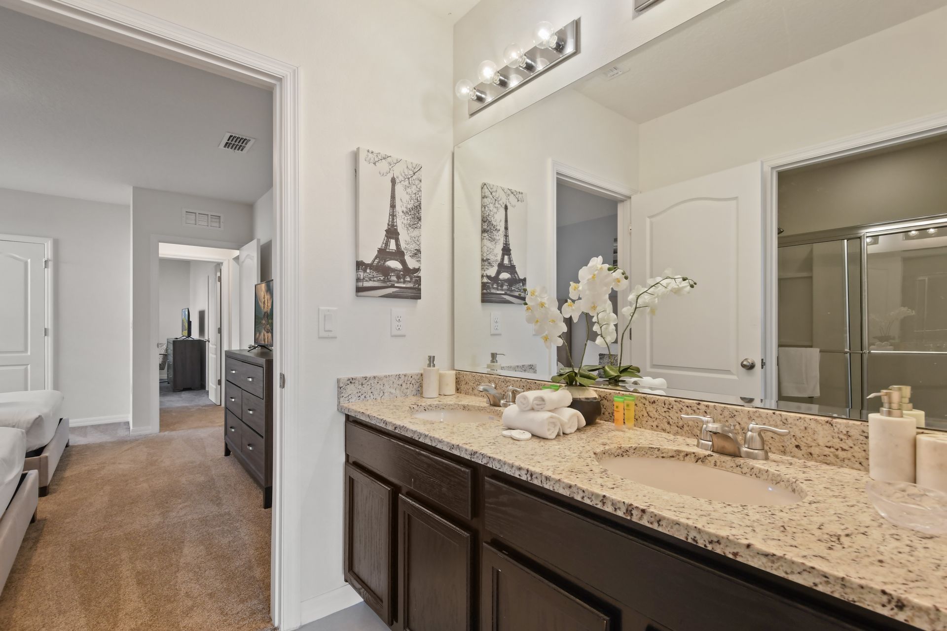 Elegant double vanity bathroom with granite counters and Parisian-inspired decor.