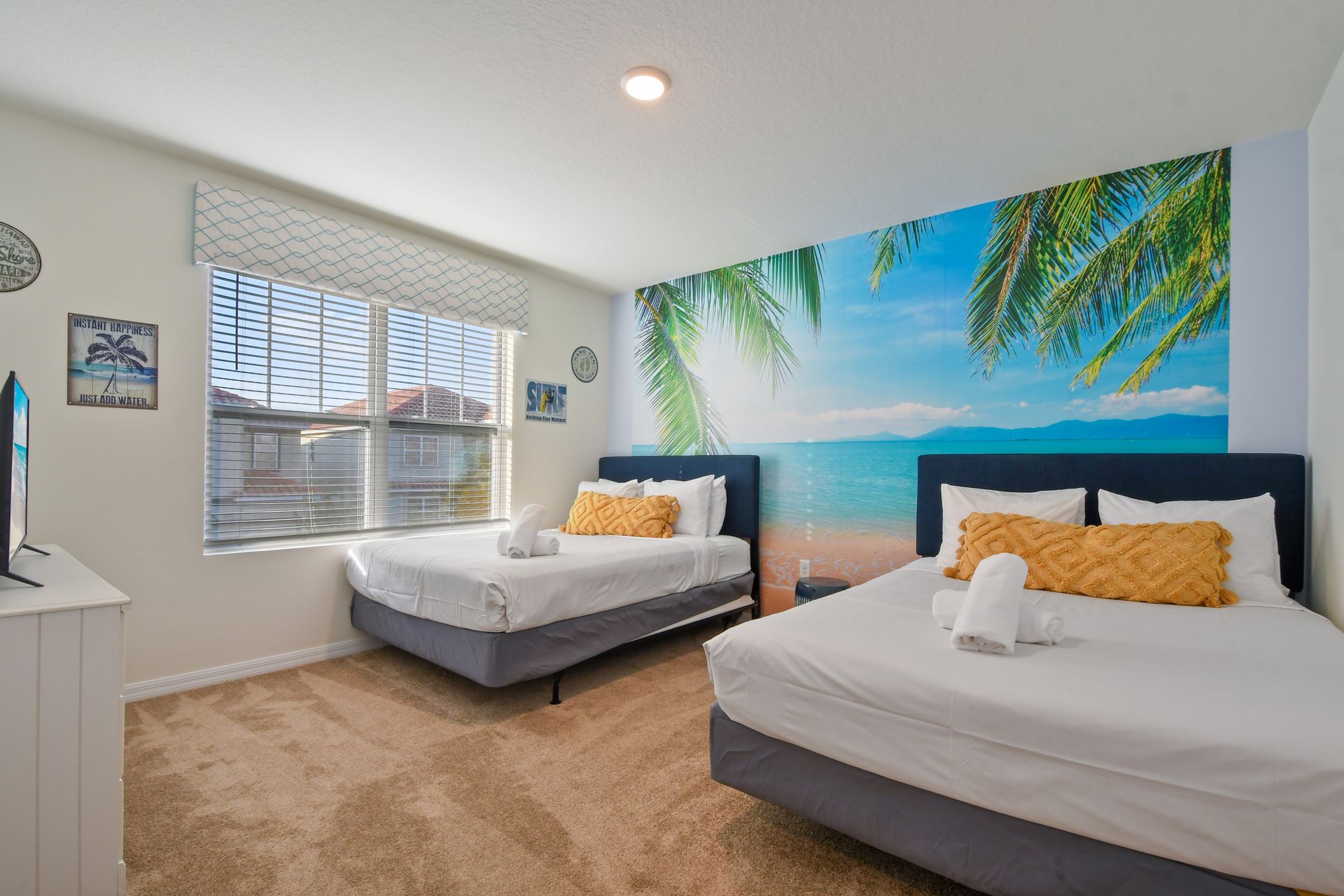 Tropical-themed double bedroom with beach mural and cozy sunny vibes.