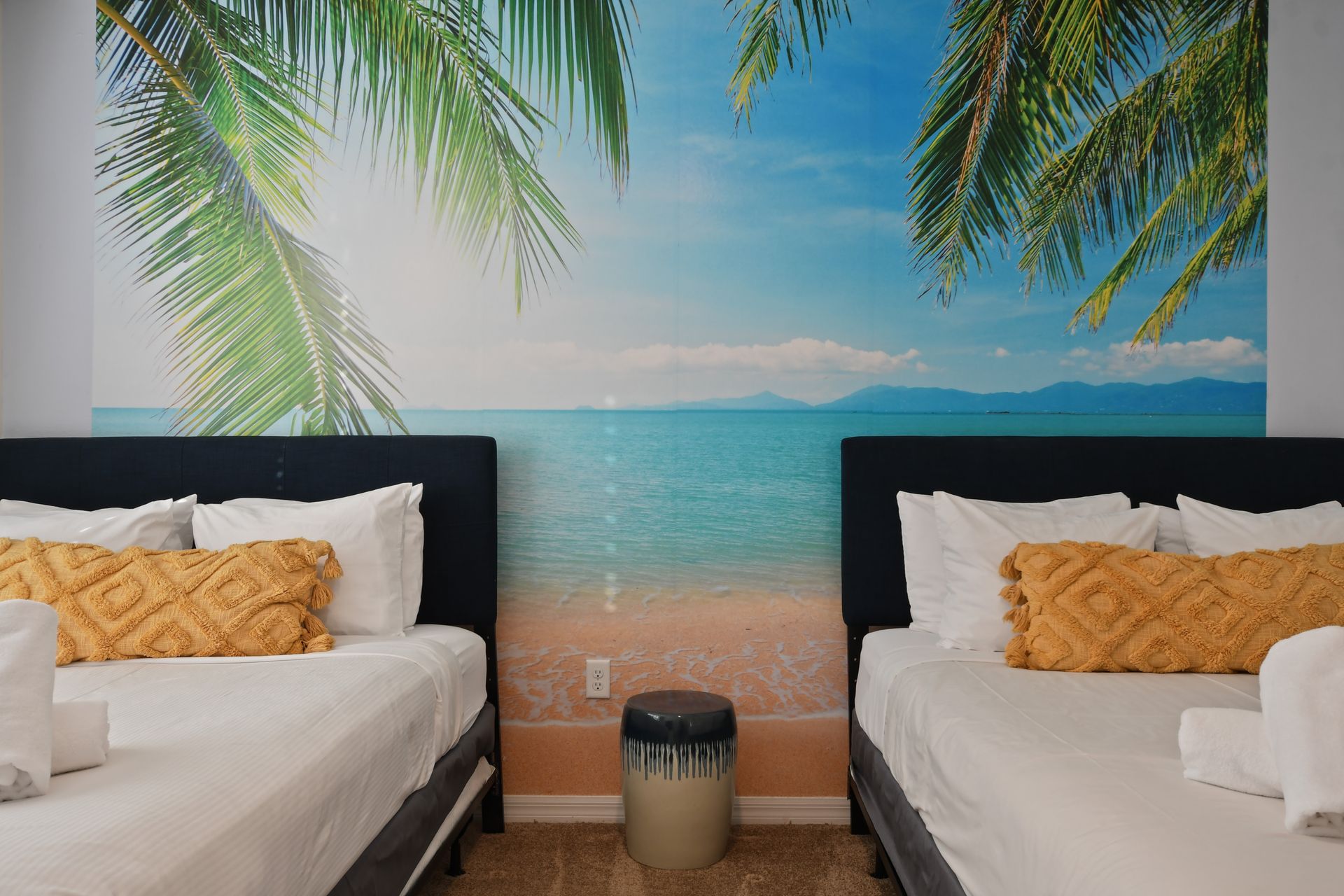 Tropical-themed double bedroom with beach mural and cozy sunny vibes.