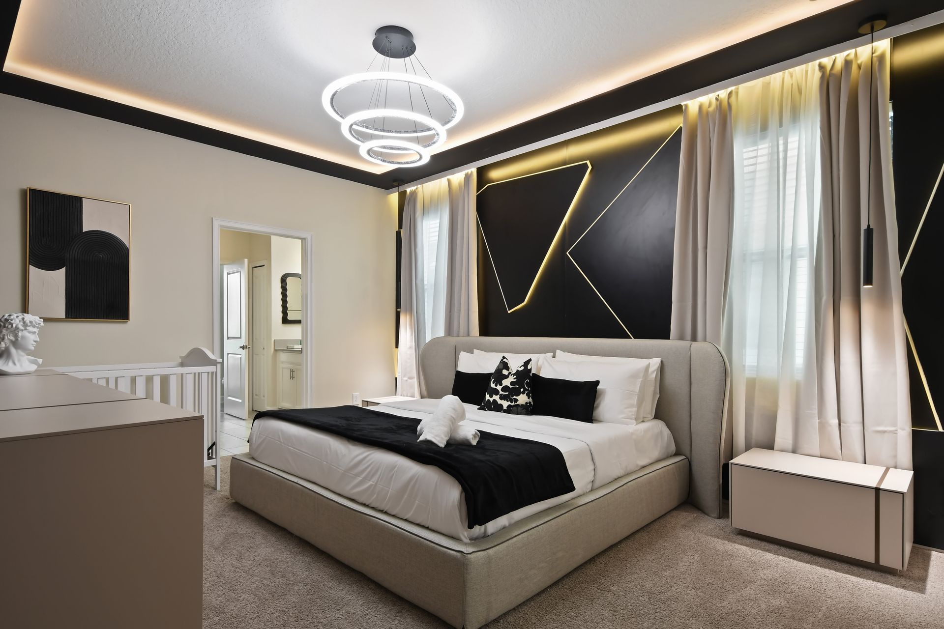 Sleep in modern luxury with bold lighting, geometric design, and a cozy king bed!