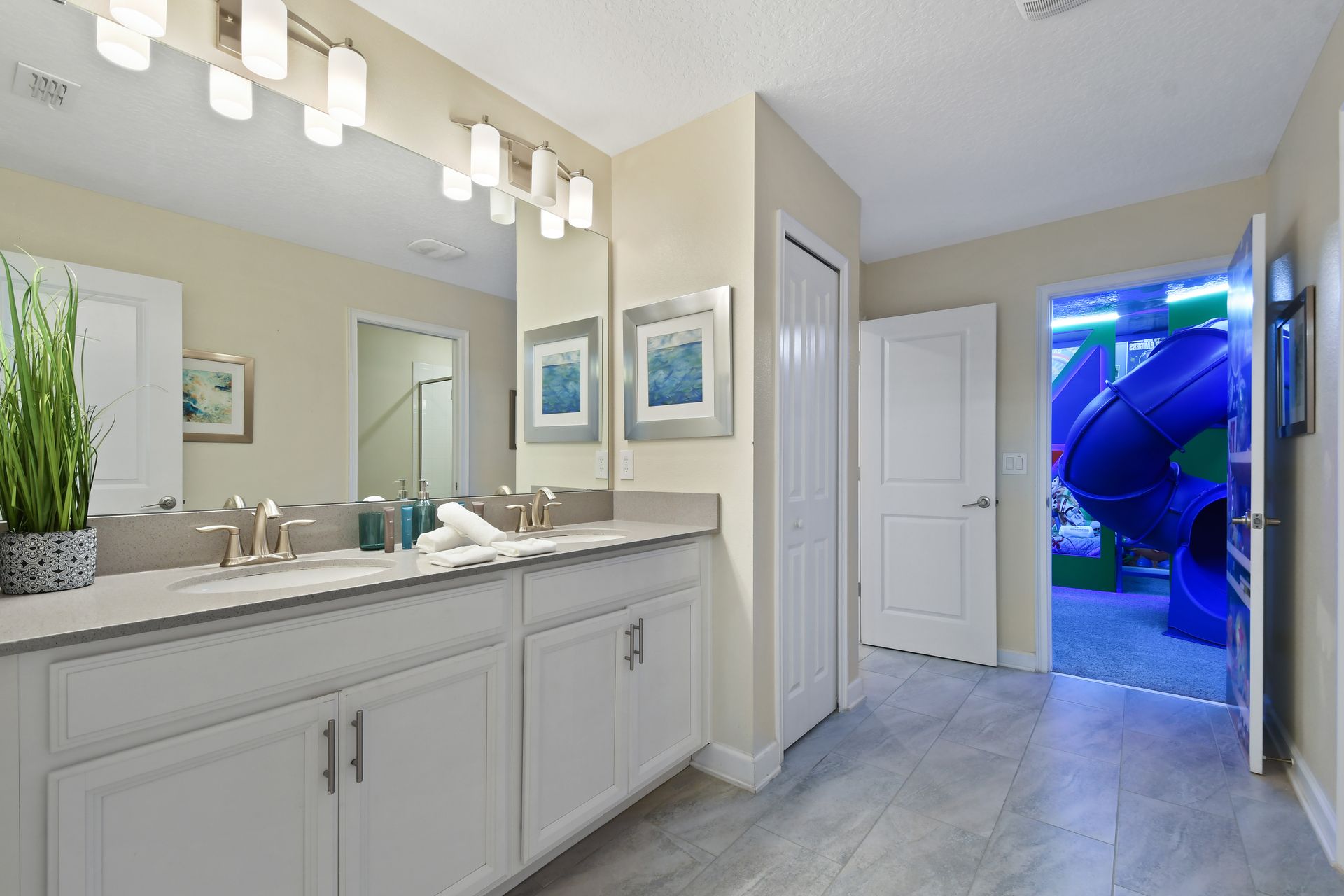 This bathroom blends style and convenience with double sinks, modern lighting, and direct access to the fun Toy Story-themed bedroom