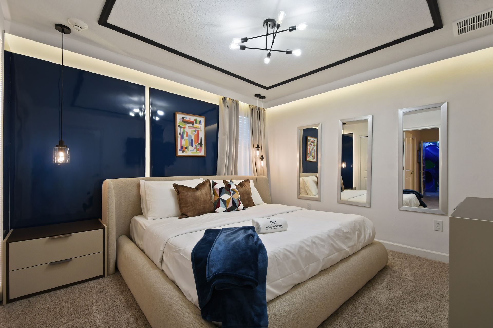 Recharge in this stylish modern bedroom with bold navy accents and designer lighting!