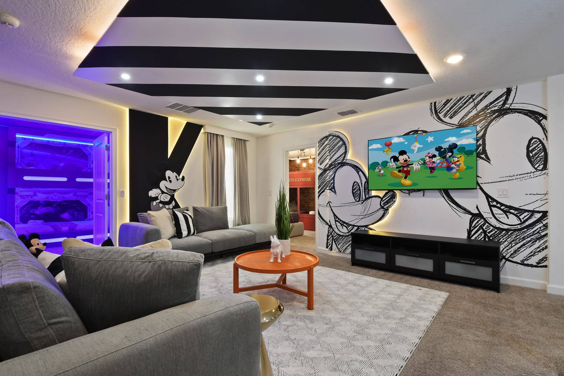 Get cozy in this playful Mickey-themed lounge, perfect for movie nights and magic!