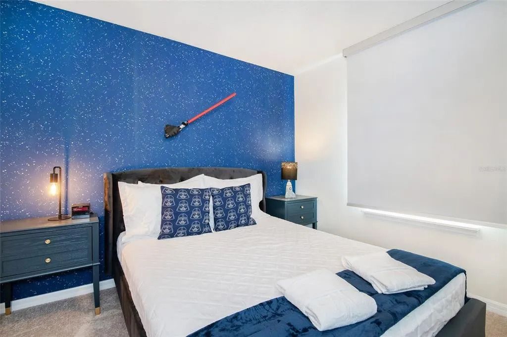 Galactic-themed bedroom with starry wall, cozy bedding, and fun space decor.