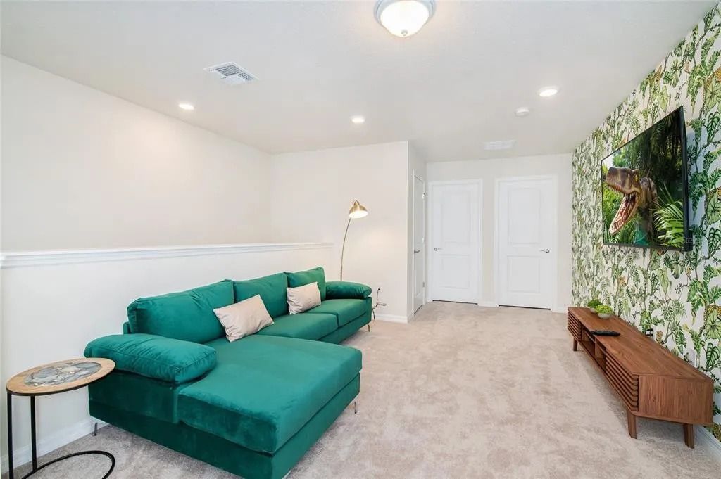 Tropical-themed loft with plush sectional and big-screen TV for movie nights.