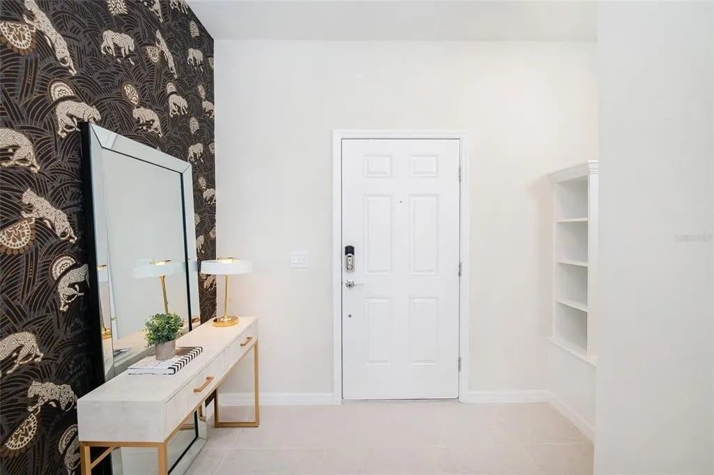 Stylish entryway with bold wallpaper, elegant console, and welcoming vibe.