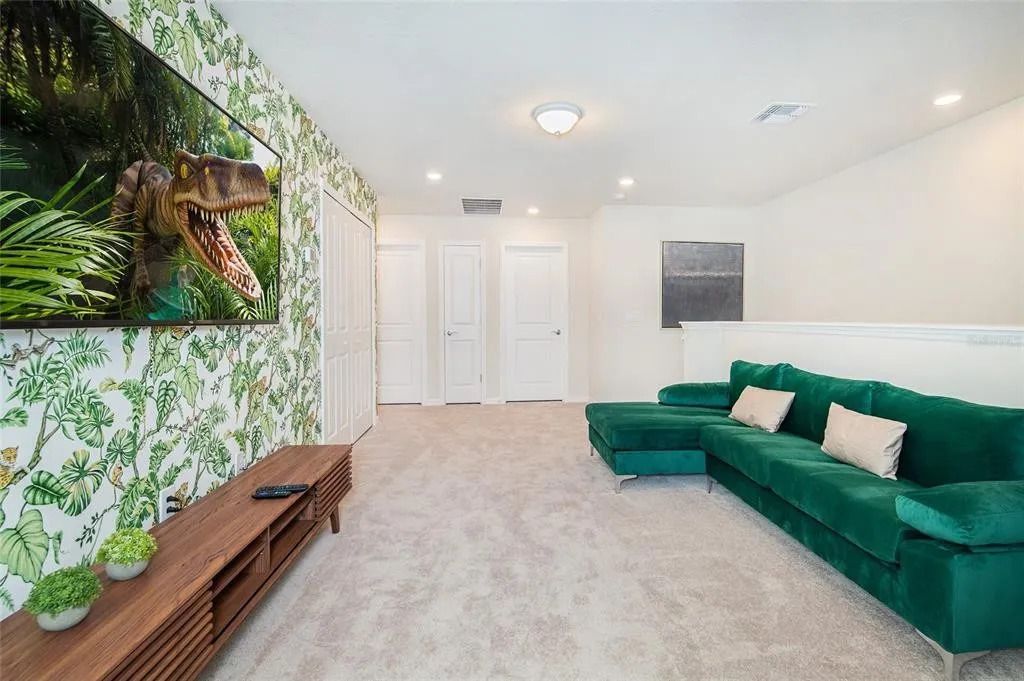 Jungle-themed loft with vibrant green sofa and epic TV setup for family fun.