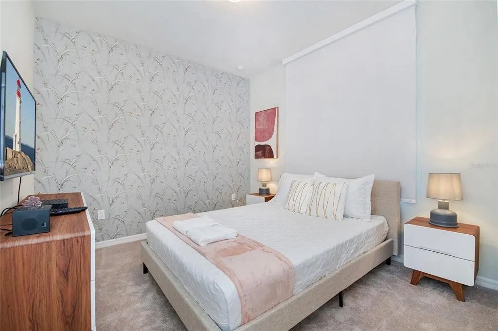 Serene bedroom with soft tones, cozy bedding, and elegant botanical wallpaper.