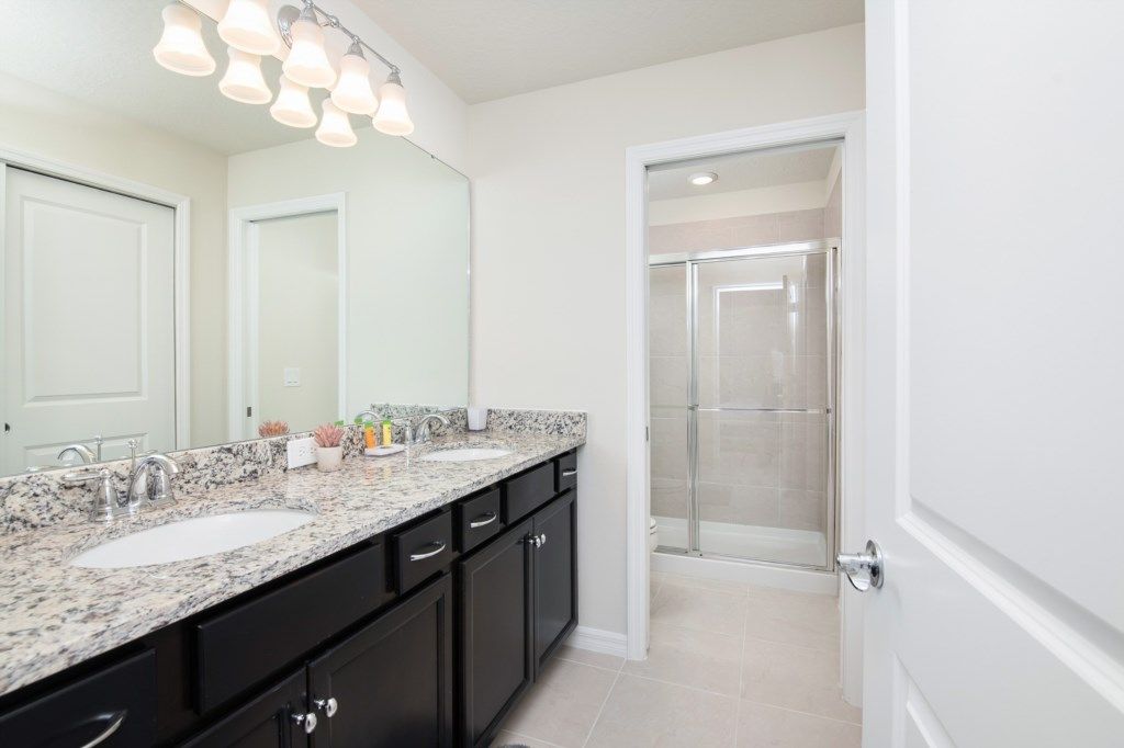 Spacious bathroom with double sinks, granite countertops, and walk-in shower.