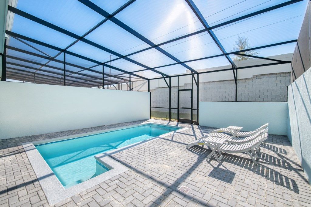 Relax in your private screened-in pool oasis with loungers and outdoor dining.