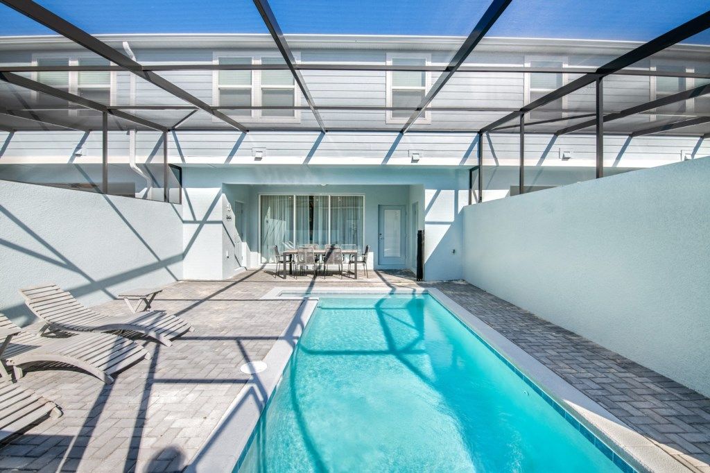Relax in your private screened-in pool oasis with loungers and outdoor dining.