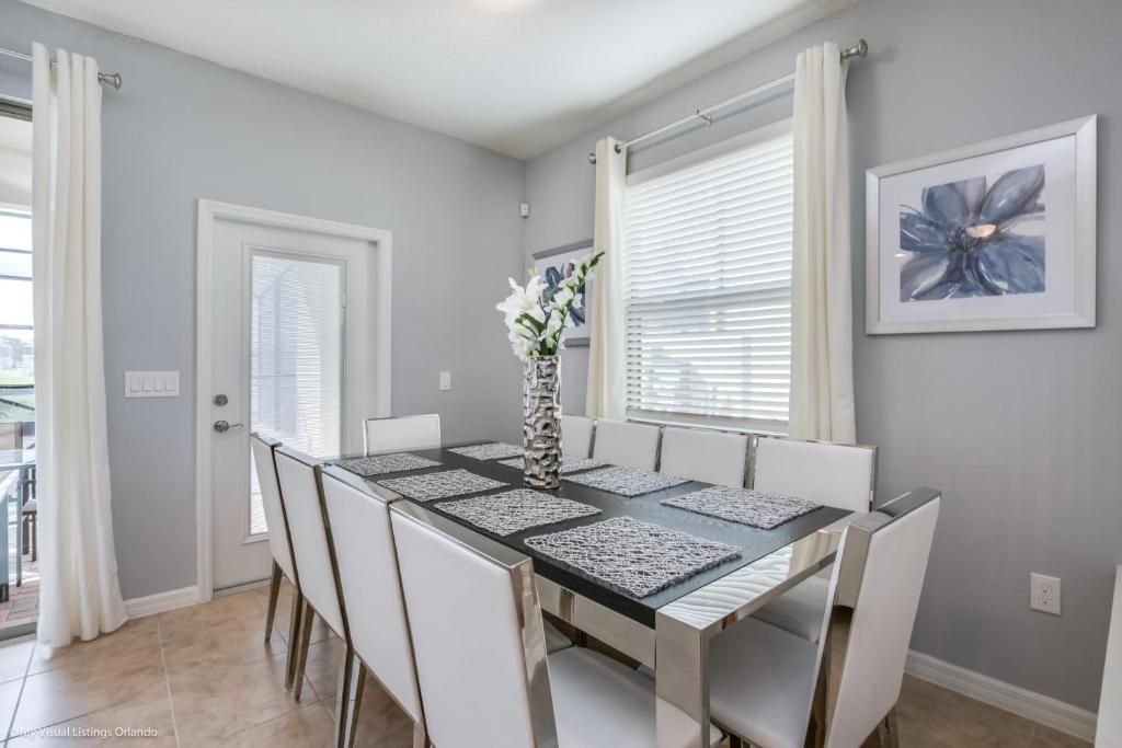 Bright dining area with sleek seating for 8, modern decor, and patio access.