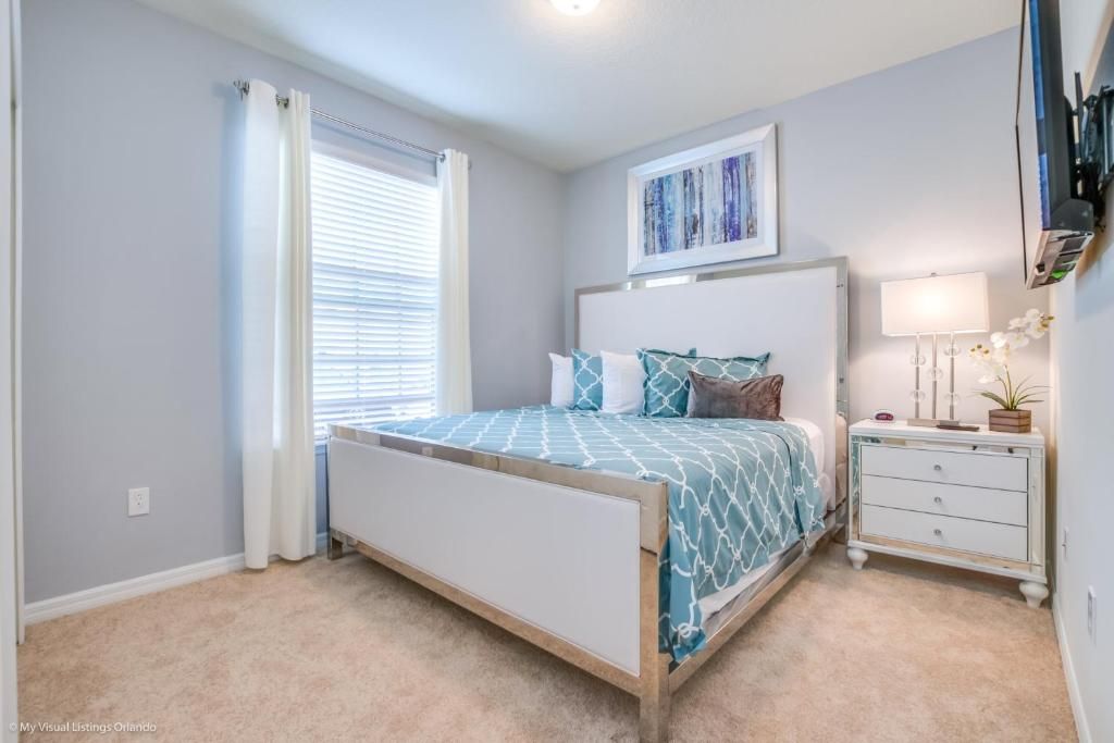 Chic queen bedroom with soft hues, modern decor, and cozy natural light.