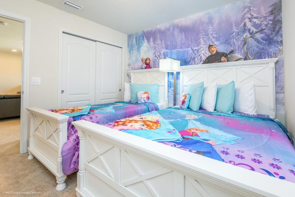Enchanting Frozen-themed twin room with snowy mural and cozy, whimsical charm.