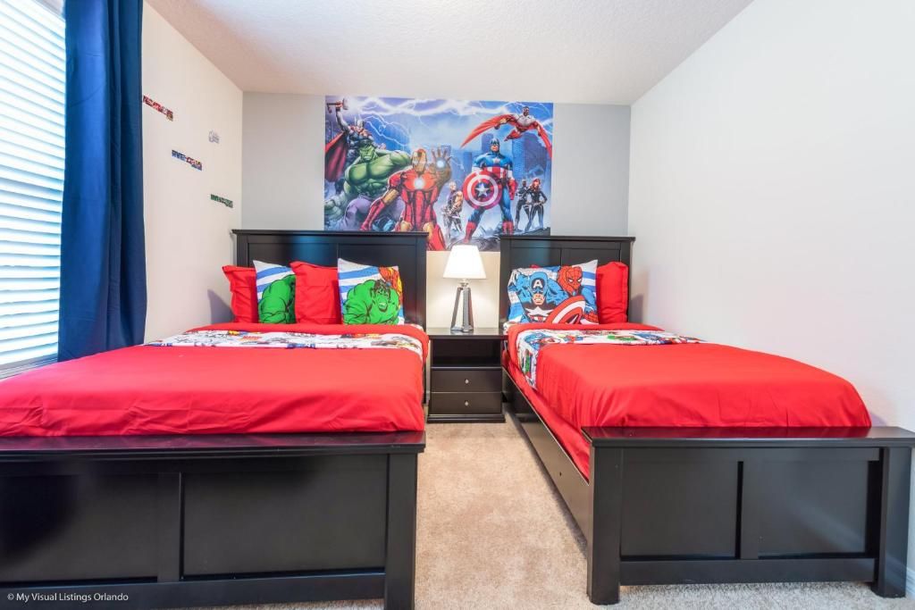 Vibrant hero-themed twin room with bold colors, fun bedding, and action-packed decor.