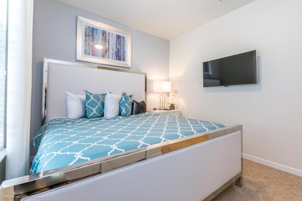 Tranquil queen bedroom with modern style, plush bedding, and flat-screen TV.