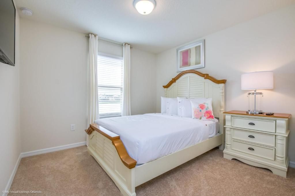Cozy queen bedroom with classic furnishings, soft lighting, and peaceful ambiance.
