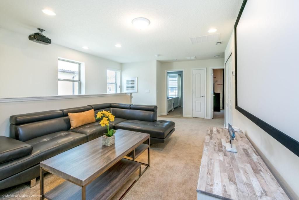 Spacious loft with comfy sectional, projector screen, and perfect movie-night setup.