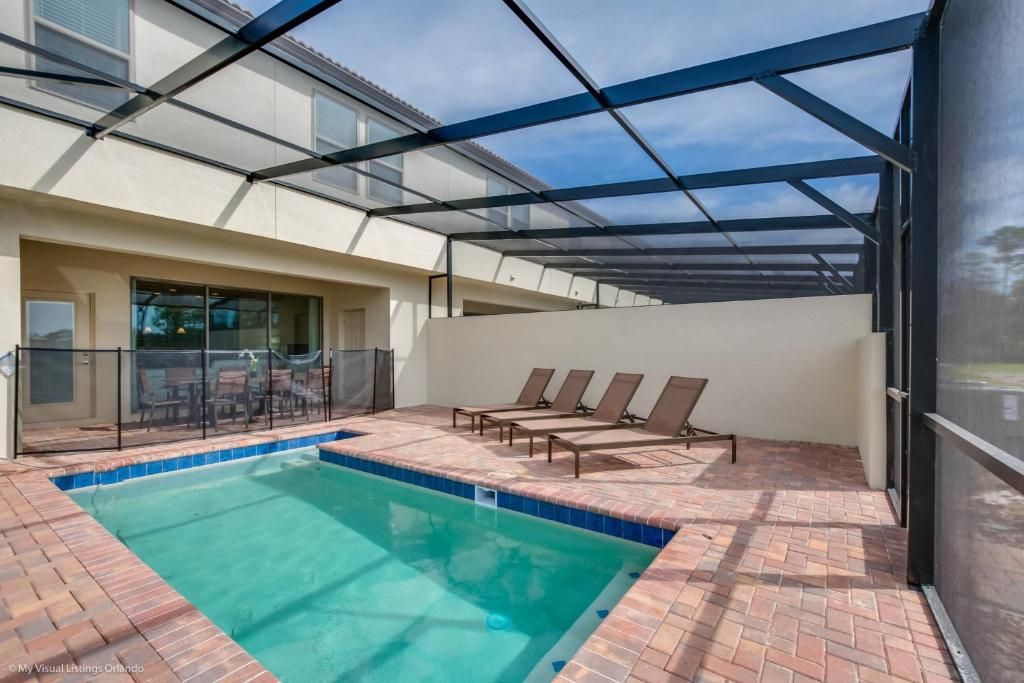 Private screened pool with sun loungers, dining space, and relaxing outdoor vibes.
