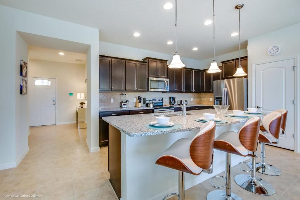 Modern kitchen with granite island, sleek appliances, and stylish bar seating for 4.
