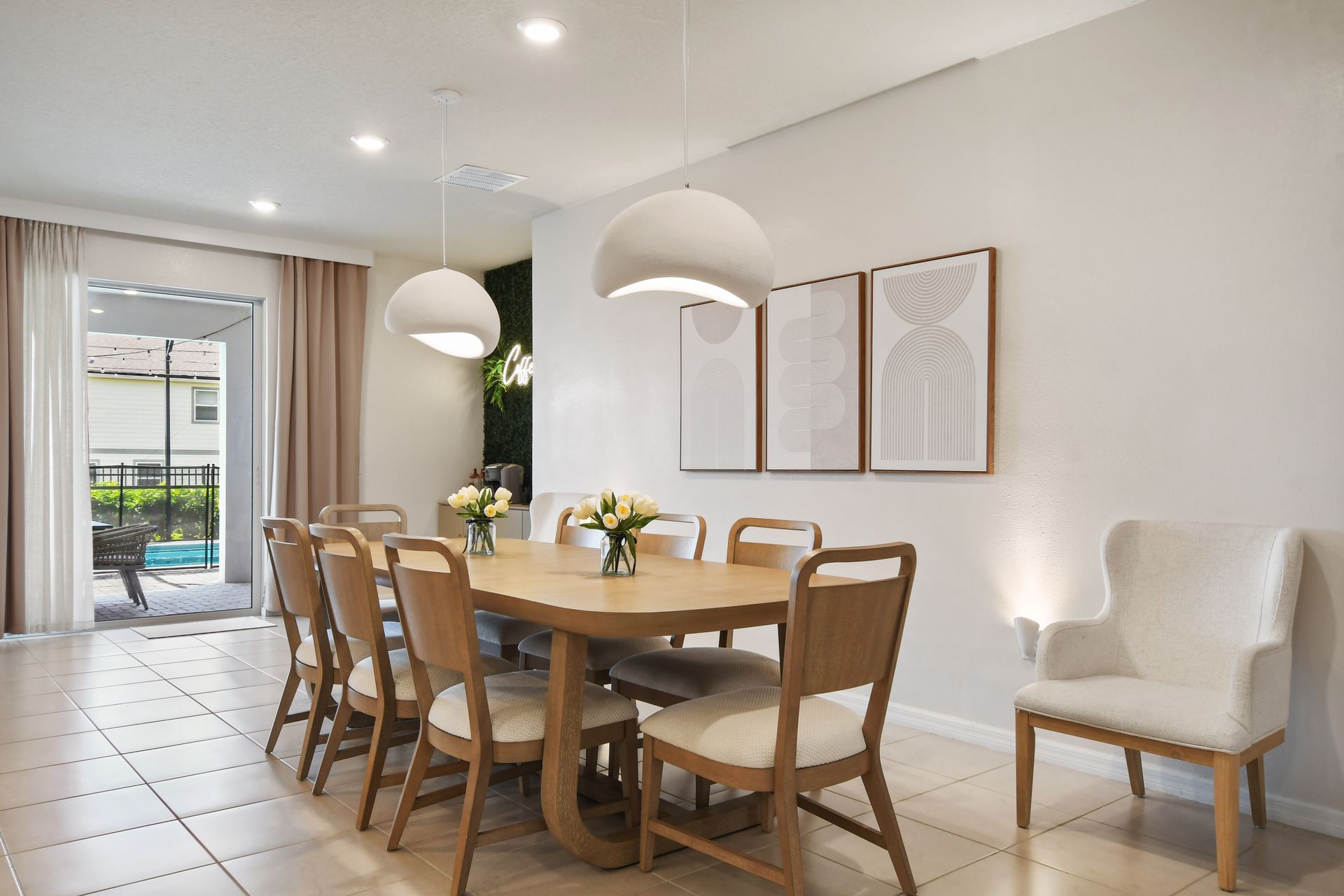 Elegant dining setup for 8 with stylish pendant lighting, poolside view, and cozy vibes!