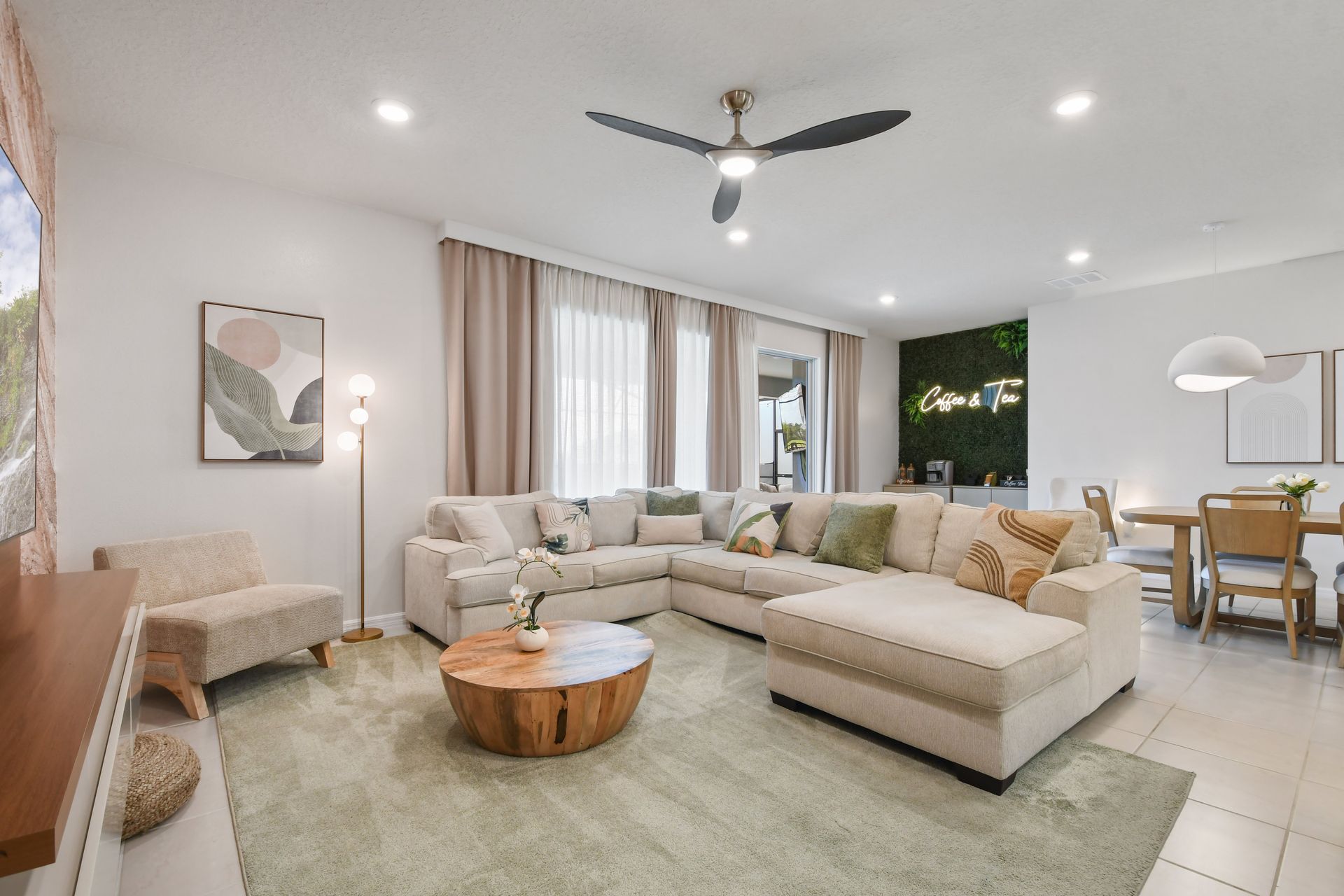 Unwind in this serene living space with a cozy sectional, chic decor, and dining area!