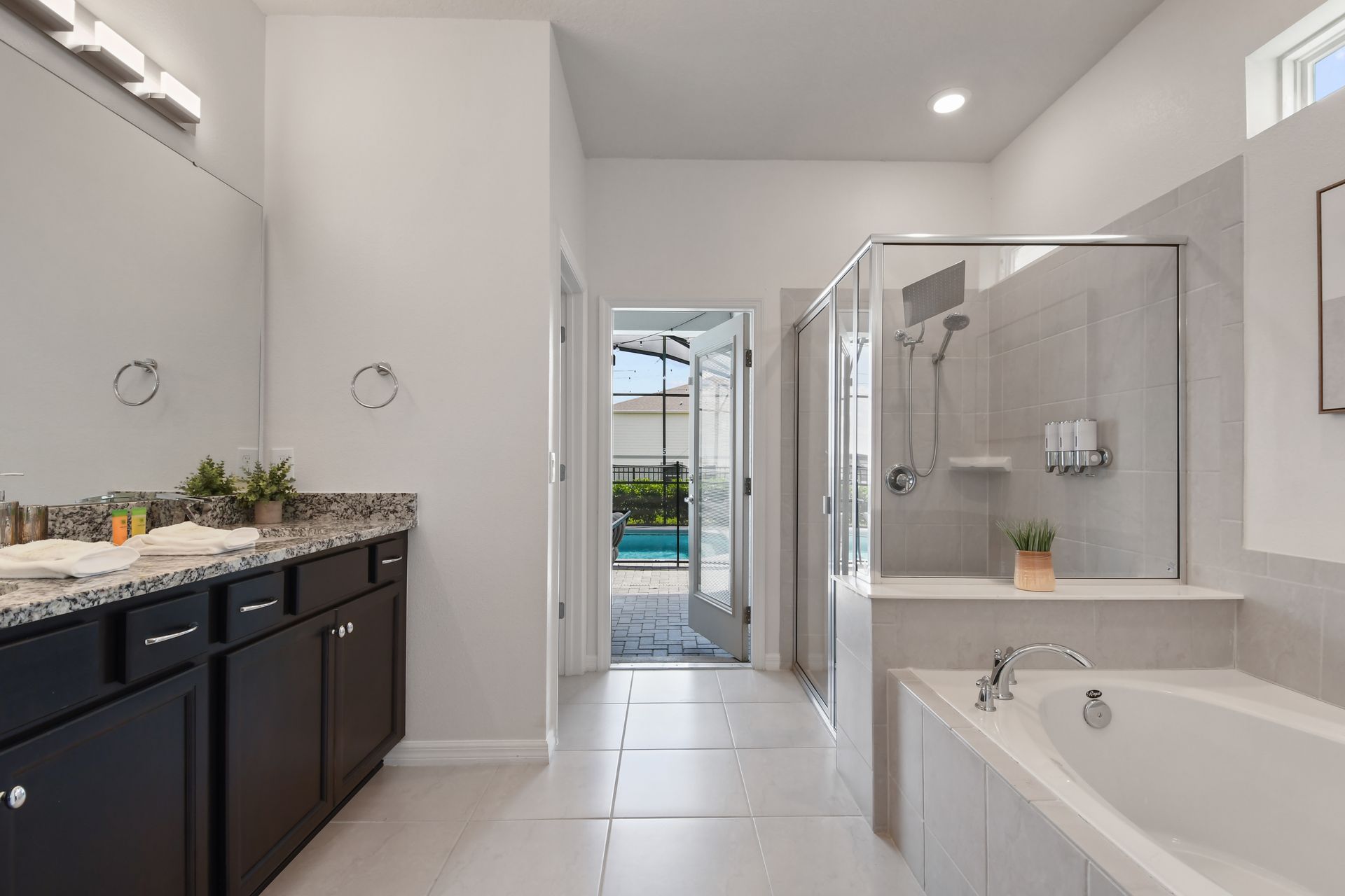 Spacious bathroom with tub, shower, and poolside access.
